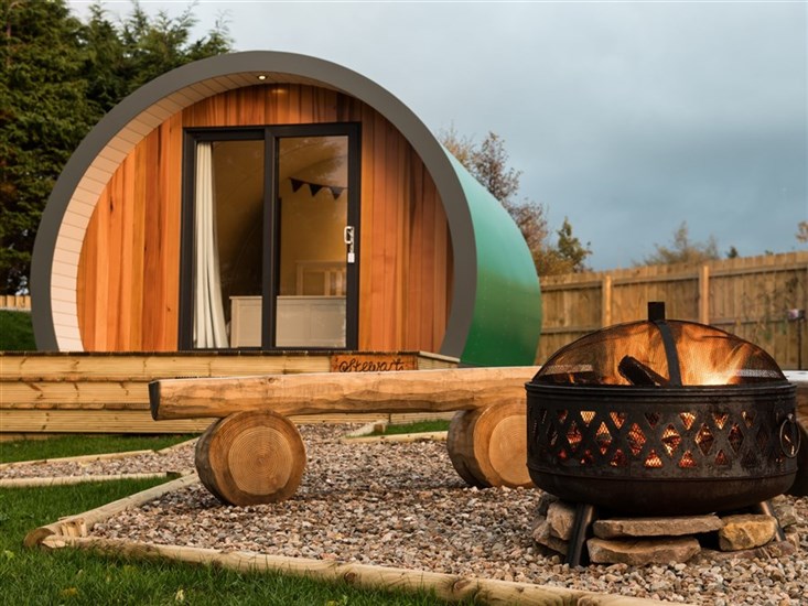 Luxury glamping pods and campfire